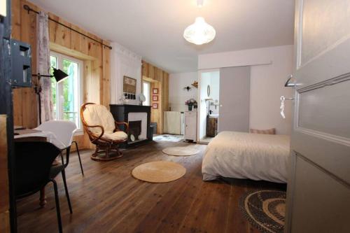 a bedroom with a bed and a table and a desk at Charmant studio avec jardin à la campagne sur le chemin de Saint Jacques de Compostelle in Lauzerte