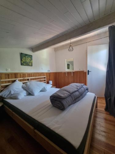 une chambre avec un grand lit avec une tête de lit en bois dans l'établissement Maison avec piscine au cœur des Gorges de l'Ardèche, à Balazuc