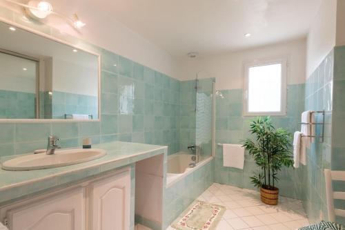 une salle de bain avec un lavabo, une baignoire et un miroir dans l'établissement Le Mas du Miel d'Or, 12 pers, au coeur du Luberon, air-conditionné, piscine, propriété de 5000 m2, à Villars