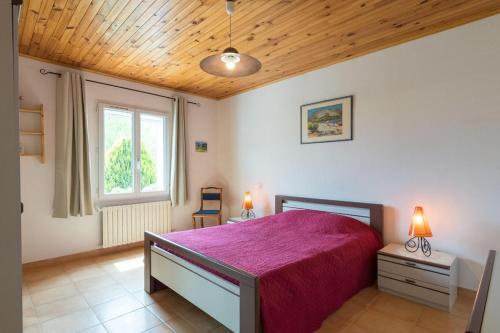 une chambre avec un grand lit avec une couverture violette dans l'établissement Le Mas du Miel d'Or, 12 pers, au coeur du Luberon, air-conditionné, piscine, propriété de 5000 m2, à Villars