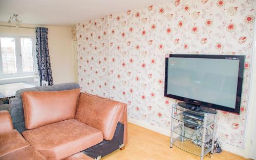 a living room with a couch and a flat screen tv at White House in Netherton