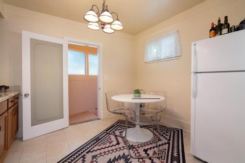 een keuken met een tafel en een koelkast bij Gomez Gardens in Santa Fe