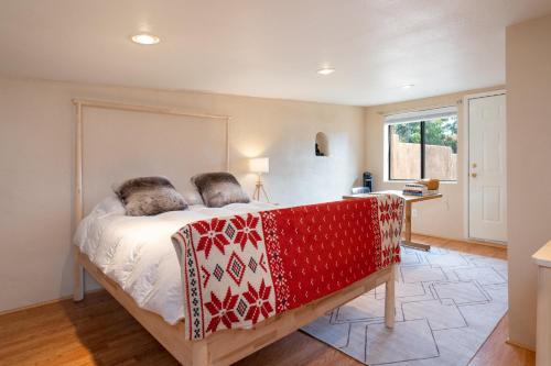 a bedroom with a bed with a red blanket on it at Gomez Gardens, 2 Bedrooms, Sleeps 4 in Santa Fe