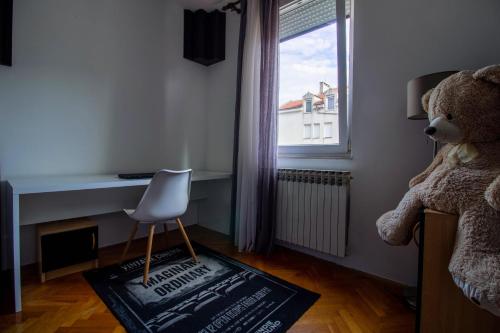a teddy bear sitting next to a desk in a bedroom at Modern oasis apartment Split PRIVATE PARKING in Split