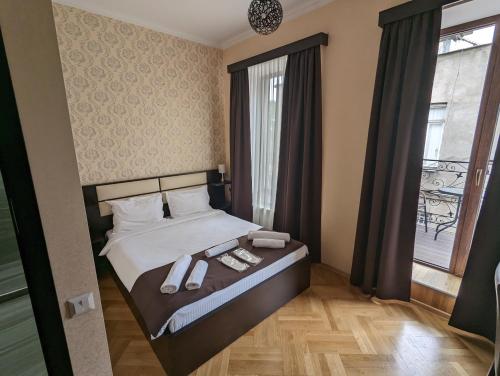 a bedroom with a bed with two towels on it at Family Guest House in Tbilisi City