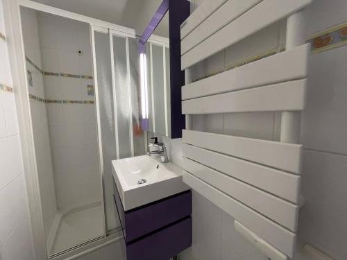 biała łazienka z umywalką i prysznicem w obiekcie Studio au coeur de la station des Menuires w Les Menuires