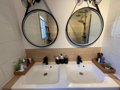 2 espejos sobre un lavabo blanco en el baño en VILLA FIORENZA, en Trets