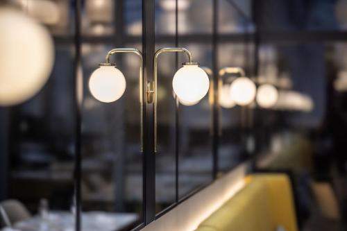 a row of lights on a table in a restaurant at Century Old Town Prague - MGallery Collection in Prague