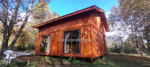 a small wooden cabin in the middle of a forest at Corazon de Panki in Curarrehue