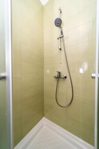 a shower with a shower head in a bathroom at Apartmani Pero Dido in Rab