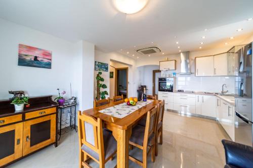 a kitchen and dining room with a wooden table and chairs at Apartmani Pero Dido in Rab