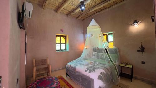 a bedroom with a bed in the corner of a room at Riad Heermans in Ouzoud