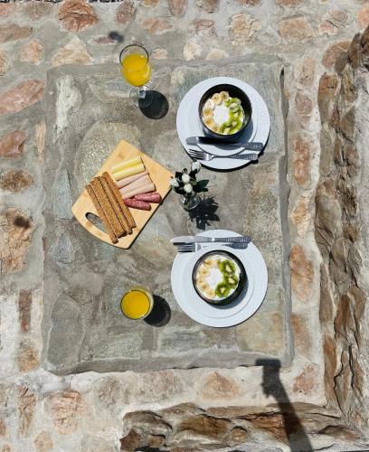 a table with plates of food and glasses of orange juice at Althea Apartments in Kolimbia