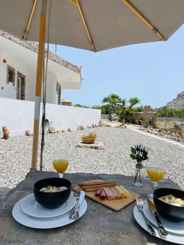 a table with two bowls of food and two glasses of orange juice at Althea Apartments in Kolimbia
