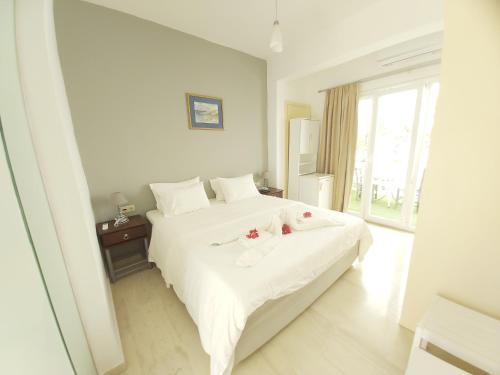a bedroom with a white bed with flowers on it at Antonios 1 in Matala