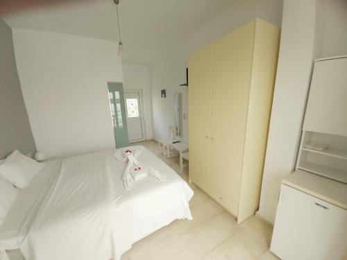 a white bedroom with a bed and a mirror at Antonios 1 in Matala