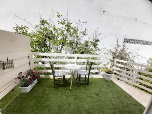 a patio with a table and chairs on the grass at Antonios 1 in Matala