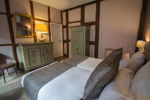 a bedroom with a large white bed with pillows at Hôtel De La Couronne in Riquewihr
