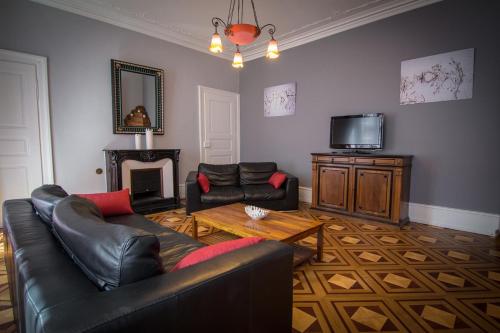 a living room with a couch and a tv at Hôtel De La Couronne in Riquewihr