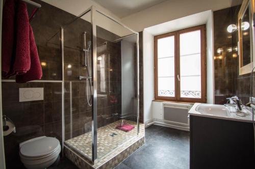 a bathroom with a shower and a toilet and a sink at Hôtel De La Couronne in Riquewihr