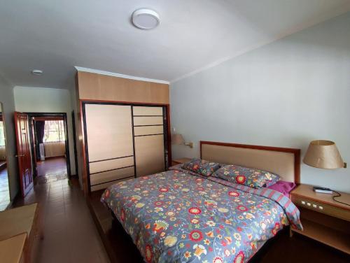 a bedroom with a bed and a lamp and a dresser at Mary Apt @ Equatorial Hill Resort in Cameron Highlands