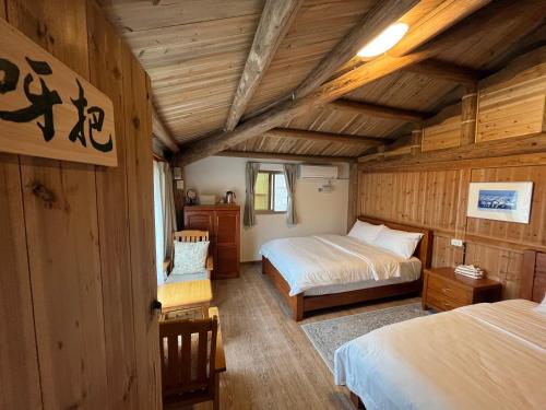 a bedroom with two beds in a wooden cabin at Horn Seaside Homestay in Nangan