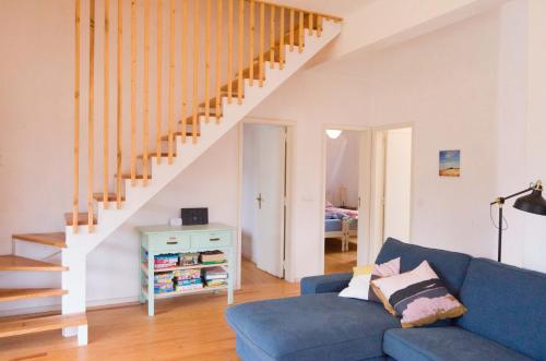 a living room with a blue couch and stairs at Casalinho in Portugal - Country House in Tomar