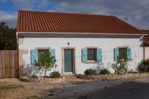 een wit huis met blauwe ramen en een hek bij Casalinho in Portugal Country House in Tomar