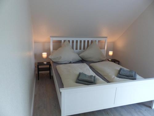 um quarto com uma cama branca e 2 almofadas em Ferienhaus Sonnenzauber 2 em Walsrode