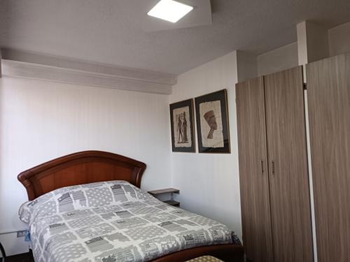 1 dormitorio con 1 cama y armario de madera en SUITE PB101 - A 5 MINUTOS DEL CENTRO HISTORICO, en Quito