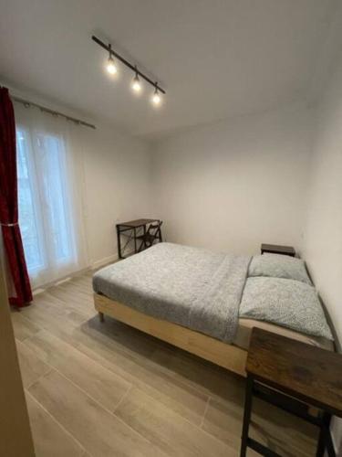 une chambre avec un lit, une table et une fenêtre dans l'établissement Paris Nordmann superbe appartement 2 pièces, à Paris