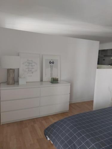 um quarto com uma cama e uma cómoda branca em Loft luminoso y céntrico em Zaragoza