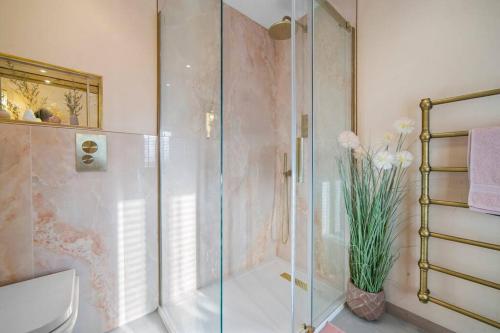 a bathroom with a glass shower and a toilet at Ysgubor Twt, Monknash in Monknash