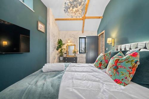 1 dormitorio con 1 cama grande y paredes azules en Ysgubor Twt, Monknash, en Monknash