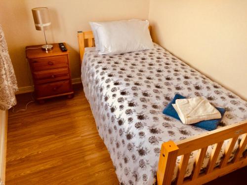 Schlafzimmer mit einem Holzbett und Holzboden in der Unterkunft Invercaul House in Inverness