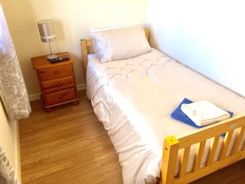 ein kleines Schlafzimmer mit einem Bett mit einem Nachttisch und einem Bett mit einem sidx sidx sidx. in der Unterkunft Invercaul House in Inverness