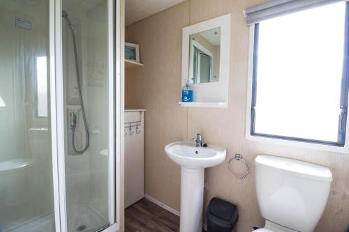 a bathroom with a toilet and a sink and a shower at 8 Berth Caravan At Highfield Grange In Essex Ref 26267e in Clacton-on-Sea