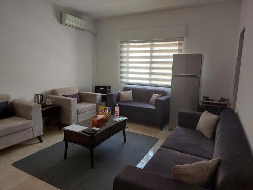 uma sala de estar com sofás e uma mesa de centro em Cozy Home 3 em Amã