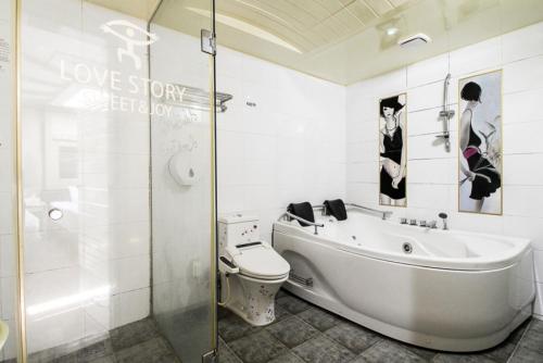 a bathroom with a tub and a toilet and a shower at Show Hotel Haeundae in Busan