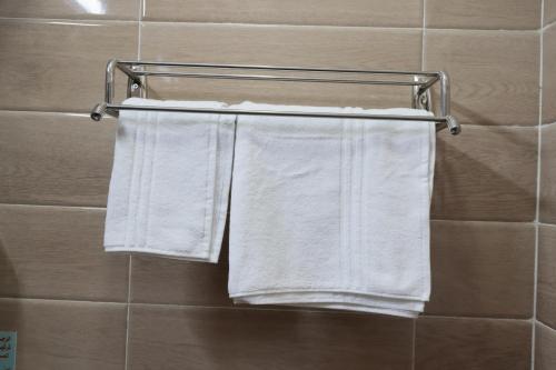 2 asciugamani sono appesi a un portasciugamani in bagno di فندق روز الجنوب a Abū Ḩajar al A‘lá