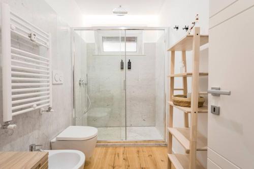 a white bathroom with a shower and a toilet at Trastevere Boutique Apartment in Rome