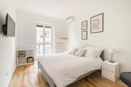 a white bedroom with a large white bed and a window at Trastevere Boutique Apartment in Rome