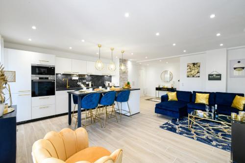 une cuisine et un salon avec des chaises bleues et une table dans l'établissement Elena YourHostHelper, à Cannes