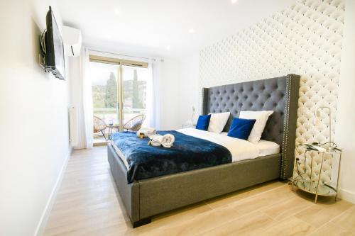 une chambre avec un grand lit avec des oreillers bleus dans l'établissement Elena YourHostHelper, à Cannes