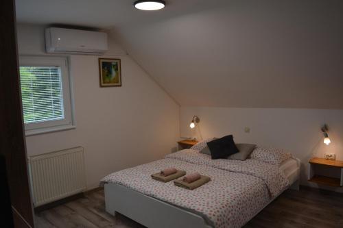 una camera da letto con un letto con due pantofole sopra di Rooms Lucijana a Jezerce