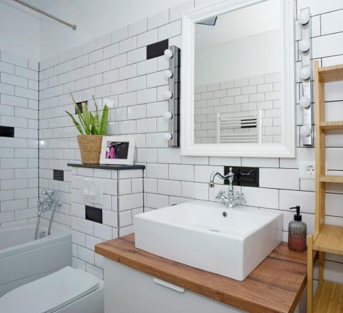 La salle de bains blanche est pourvue d'un lavabo et d'un miroir. dans l'établissement 4-star Apartments Bianco, à Kaštela