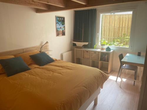 une chambre avec un lit, une table et une fenêtre dans l'établissement MAISON indépendante avec Jardin, très calme, CENTRE VILLE LA ROCHELLE, à La Rochelle