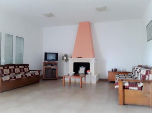 a living room with couches and a fireplace at Villa Nafsika in Plátonas