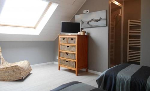 a bedroom with a bed and a tv on a dresser at Espace Acu-Nature in Saint-Évarzec