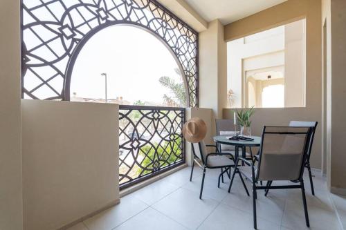a balcony with a table and chairs and a window at Vogue Vacation Homes, Madinat Jumeirah Living Rahaal Near Burj Al Arab One Bedroom Apartment with Balcony and Vibrant Community View, Access to all Amenities in Dubai